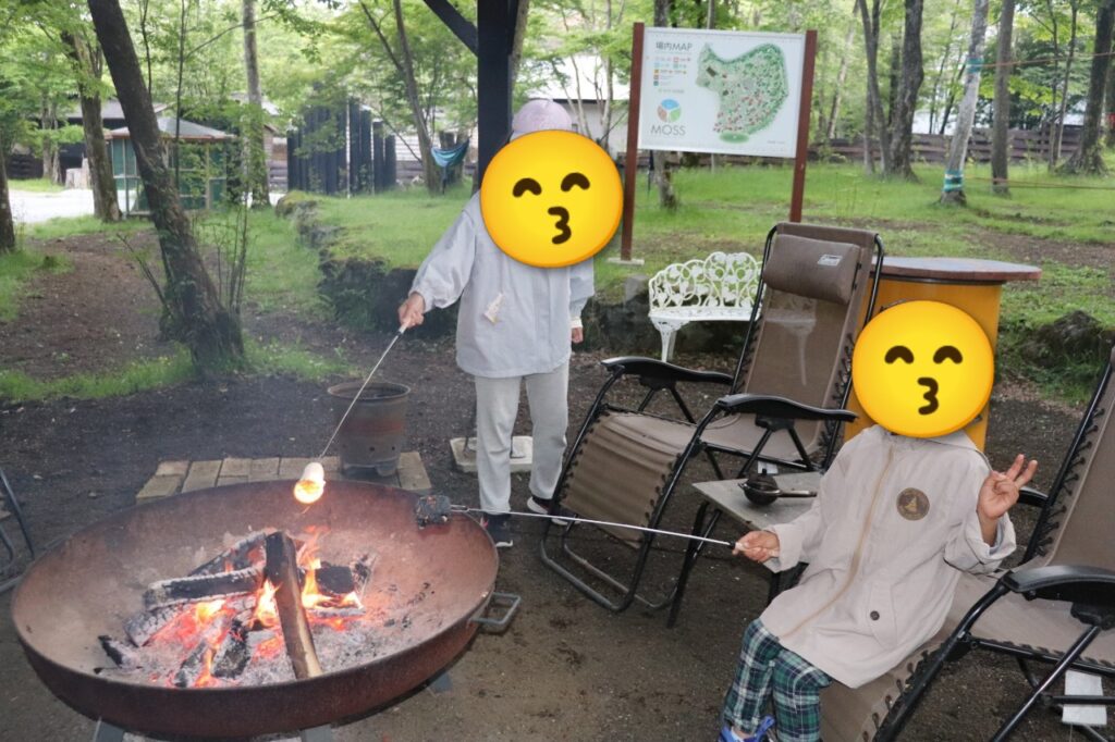 MOSS十里木キャンプリゾートのキャンプファイヤーで、長い串を使ってマシュマロを焼く子どもたちの様子