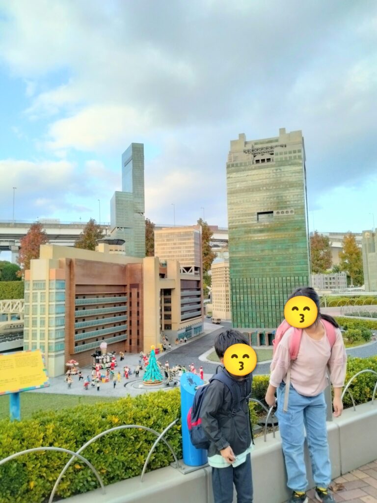 レゴブロックで再現されたミニランドの東京スカイツリーを背景に笑顔で並ぶ姉弟の写真