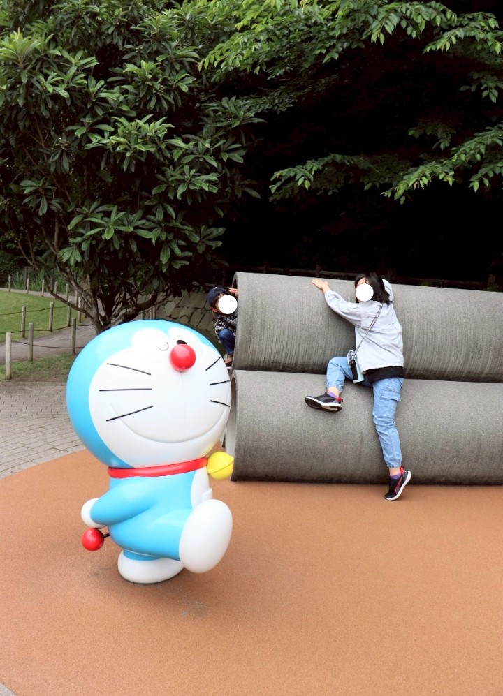 ドラえもんミュージアムのはらっぱでドラえもんと大きな土管を楽しむ姉弟