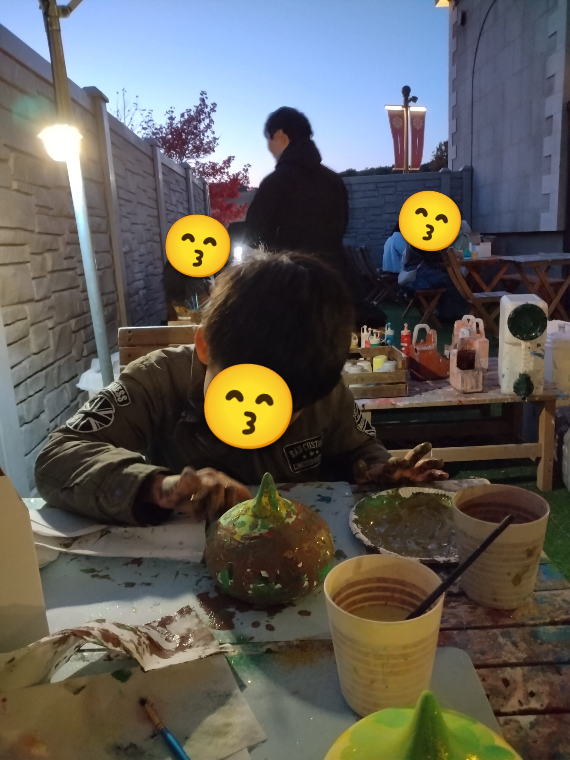 屋外でスライムの色塗り体験をする子ども
