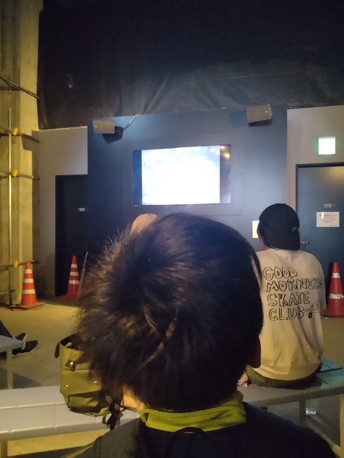 黒部ダムのトンネル内で建設の歴史映像を集中して見る大工志望のASD息子