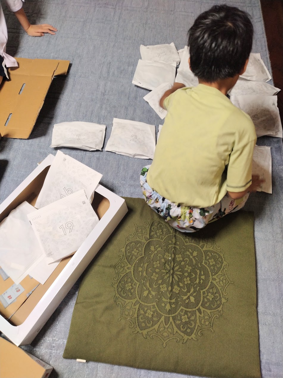 トロフィーの袋を並べて組み立てを始める息子